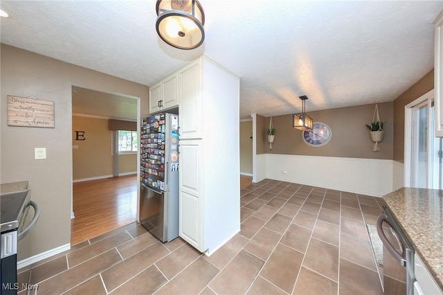 726 N Fork Way, Brunswick Hills, OH 44212 - kitchen featuring appliances with stainless steel finishes, light tile patterned floors, a wainscoted wall, white cabinets, and baseboards