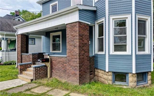 821 9th St SW, Massillon, OH 44647 - view of side of home featuring covered porch and brick siding