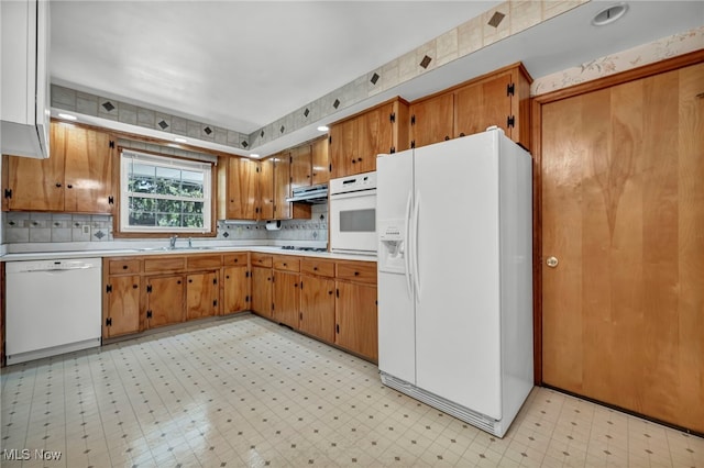 50 Luikart Dr, Euclid, OH 44123 - kitchen with white appliances, under cabinet range hood, light flooring, a sink, and light countertops