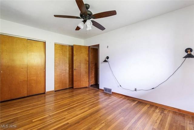 600 Elson St, East Liverpool, OH 43920 - unfurnished bedroom featuring two closets, wood-type flooring, baseboards, and ceiling fan
