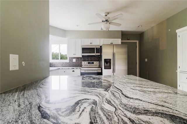 600 Elson St, East Liverpool, OH 43920 - kitchen with appliances with stainless steel finishes, white cabinetry, a ceiling fan, light stone counters, and tasteful backsplash