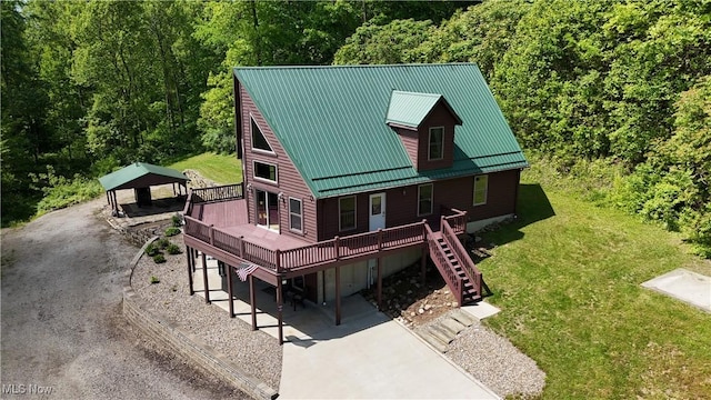 693 Evening Star Ave SE, East Canton, OH 44730 - view of front of home featuring a wooden deck, a front lawn, stairway, metal roof, and a wooded view