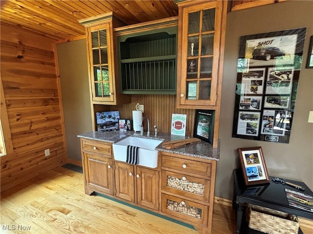 693 Evening Star Ave SE, East Canton, OH 44730 - kitchen with a sink, wood ceiling, wooden walls, light wood finished floors, and brown cabinets