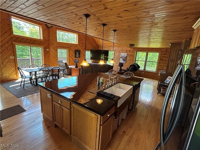 693 Evening Star Ave SE, East Canton, OH 44730 - kitchen featuring open floor plan, wood walls, wood ceiling, a center island with sink, and light wood-style flooring