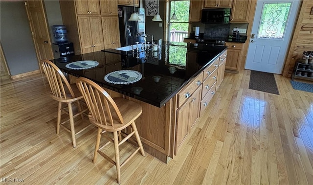 693 Evening Star Ave SE, East Canton, OH 44730 - kitchen featuring black appliances, dark countertops, light wood finished floors, and a sink