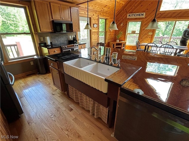 693 Evening Star Ave SE, East Canton, OH 44730 - kitchen featuring black microwave, light wood-style flooring, wooden walls, hanging light fixtures, and stainless steel range with electric stovetop