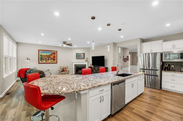7834 Hunting Lake Dr, Concord, OH 44077 - kitchen featuring appliances with stainless steel finishes, open floor plan, a sink, light wood-type flooring, and recessed lighting