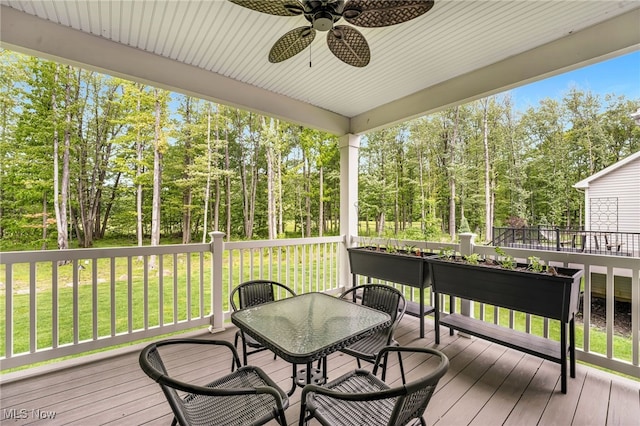 7834 Hunting Lake Dr, Concord, OH 44077 - wooden terrace with a ceiling fan, outdoor dining area, view of scattered trees, and a yard
