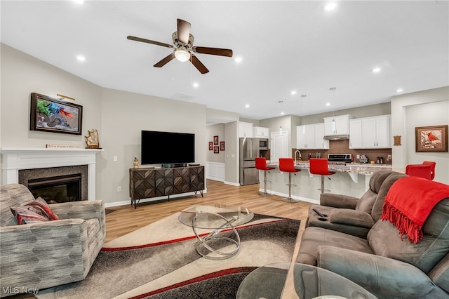 7834 Hunting Lake Dr, Concord, OH 44077 - living area with a ceiling fan, light wood-style flooring, recessed lighting, a glass covered fireplace, and baseboards