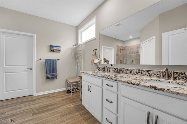 7834 Hunting Lake Dr, Concord, OH 44077 - bathroom with a stall shower, double vanity, baseboards, and wood finished floors