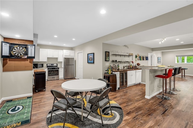 7834 Hunting Lake Dr, Concord, OH 44077 - dining space with bar with sink, wine cooler, wood finished floors, recessed lighting, and baseboards