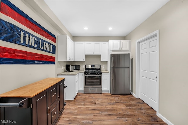 7834 Hunting Lake Dr, Concord, OH 44077 - kitchen featuring stainless steel appliances, white cabinets, butcher block countertops, wood finished floors, and recessed lighting