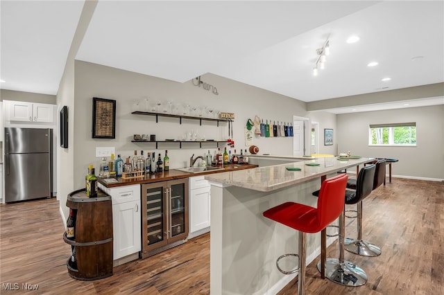 7834 Hunting Lake Dr, Concord, OH 44077 - indoor wet bar featuring freestanding refrigerator, wine cooler, wood finished floors, and recessed lighting