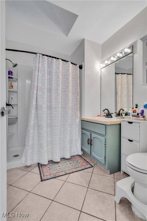 7773 Lutz Ave NW, Massillon, OH 44646 - full bath featuring toilet, vanity, tile patterned floors, and curtained shower