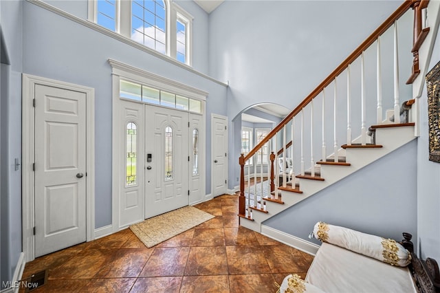 8041 Daisy Hill Ct, Concord, OH 44077 - entrance foyer featuring a high ceiling, baseboards, arched walkways, and stairs