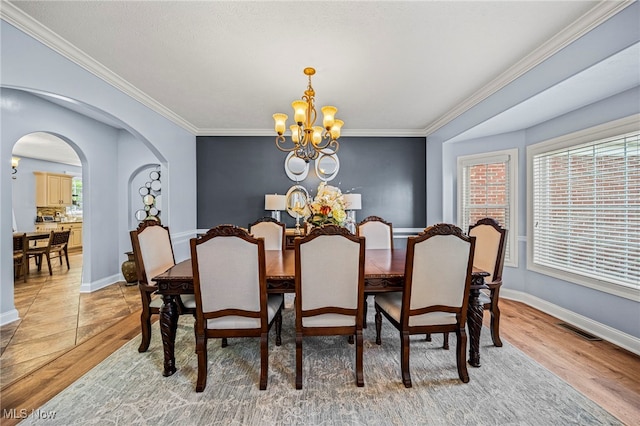 8041 Daisy Hill Ct, Concord, OH 44077 - dining area with a chandelier, arched walkways, crown molding, light wood-style floors, and baseboards