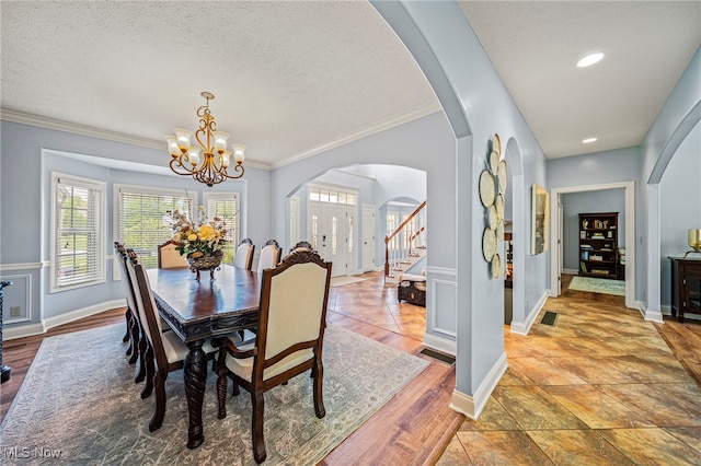 8041 Daisy Hill Ct, Concord, OH 44077 - dining room with arched walkways, ornamental molding, a chandelier, stairs, and a textured ceiling