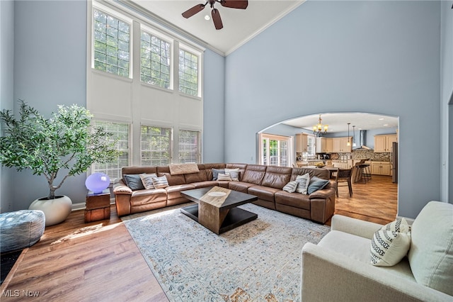 8041 Daisy Hill Ct, Concord, OH 44077 - living area with high vaulted ceiling, arched walkways, a ceiling fan, crown molding, and a chandelier