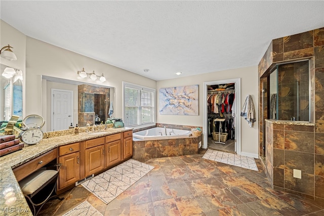 8041 Daisy Hill Ct, Concord, OH 44077 - bathroom with a bath, a shower stall, stone finish floors, vanity, and a textured ceiling