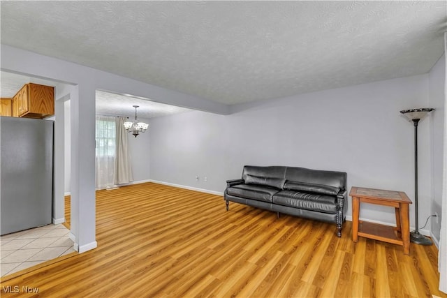 378 Stahl Ave, Cortland, OH 44410 - sitting room with a chandelier, light wood-style flooring, a textured ceiling, and baseboards