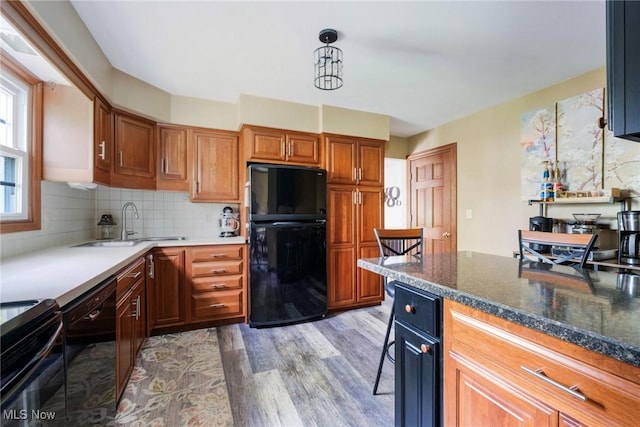 410 Hickory Hollow Dr, Canfield, OH 44406 - kitchen with black appliances, wood finished floors, decorative backsplash, a sink, and brown cabinets