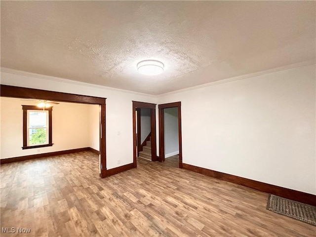 616 Mccready Ave, Cadiz, OH 43907 - empty room with wood finished floors, baseboards, a textured ceiling, and ornamental molding