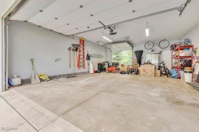 6254 Mackenzie Rd, North Olmsted, OH 44070 - garage featuring a garage door opener and white refrigerator with ice dispenser