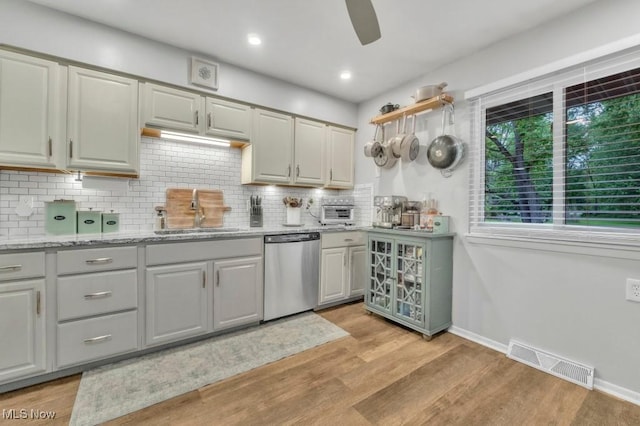 6254 Mackenzie Rd, North Olmsted, OH 44070 - kitchen featuring dishwasher, a sink, light wood finished floors, backsplash, and baseboards