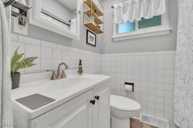 6254 Mackenzie Rd, North Olmsted, OH 44070 - bathroom featuring tile walls, vanity, toilet, and wainscoting