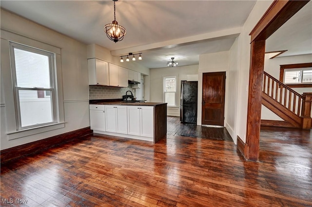 802 N Main St, Uhrichsville, OH 44683 - kitchen with a chandelier, dark countertops, freestanding refrigerator, a peninsula, and dark wood-style flooring