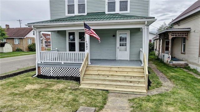 802 N Main St, Uhrichsville, OH 44683 - view of front of property featuring covered porch, a standing seam roof, metal roof, and a front lawn