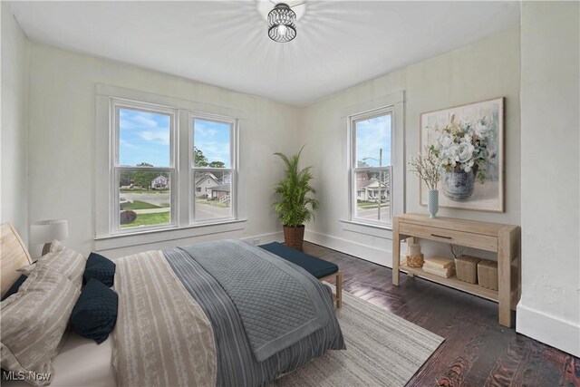 802 N Main St, Uhrichsville, OH 44683 - bedroom featuring multiple windows, dark wood-style flooring, and baseboards