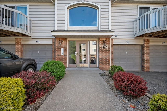 1444 Buckingham Gate Blvd Unit H, Cuyahoga Falls, OH 44221 - doorway to property with an attached garage, brick siding, and a balcony