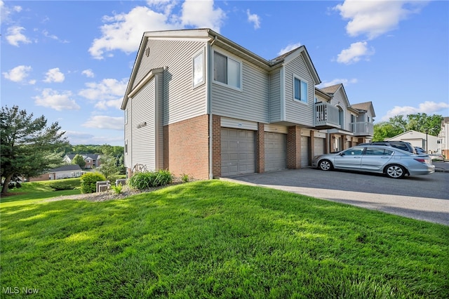 1444 Buckingham Gate Blvd Unit H, Cuyahoga Falls, OH 44221 - view of property exterior featuring brick siding, a garage, a lawn, asphalt driveway, and a residential view