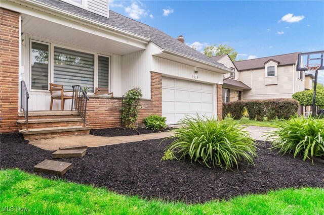 2524 Claver Rd, University Heights, OH 44118 - view of front of home featuring a garage, a porch, a shingled roof, brick siding, and a chimney