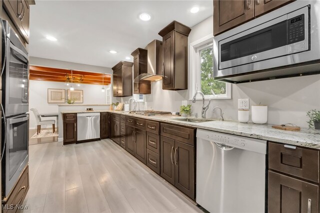 2524 Claver Rd, University Heights, OH 44118 - kitchen featuring appliances with stainless steel finishes, a sink, dark brown cabinetry, light wood-style flooring, and light stone counters