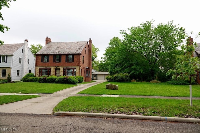 2323 Miramar Blvd, University Heights, OH 44118 - tudor house featuring a front lawn, brick siding, and a garage