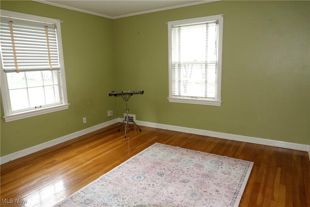 2323 Miramar Blvd, University Heights, OH 44118 - empty room with crown molding, wood finished floors, baseboards, and healthy amount of natural light