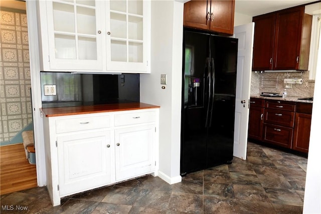 2323 Miramar Blvd, University Heights, OH 44118 - kitchen with black refrigerator with ice dispenser, decorative backsplash, baseboards, glass insert cabinets, and stone finish floors