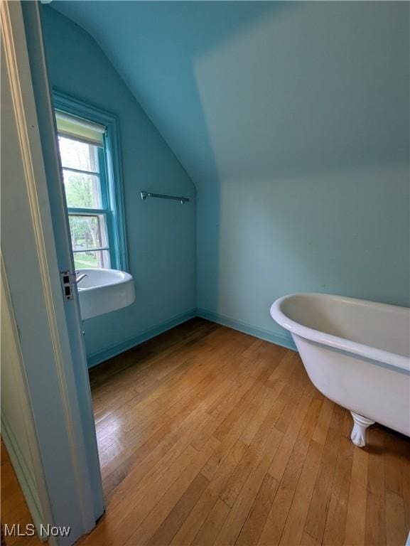 2323 Miramar Blvd, University Heights, OH 44118 - bathroom with vaulted ceiling, a freestanding tub, hardwood / wood-style floors, and baseboards