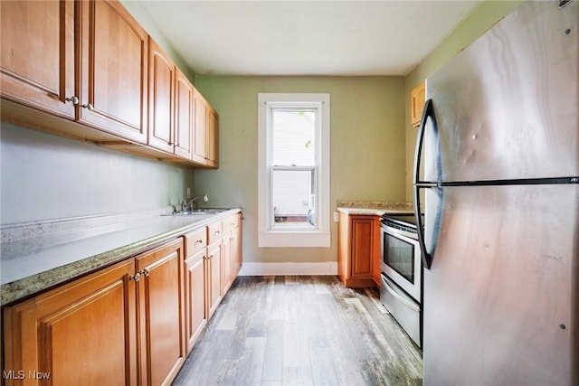 492 W Pershing St, Salem, OH 44460 - kitchen with appliances with stainless steel finishes, light wood-style flooring, baseboards, a sink, and light stone counters