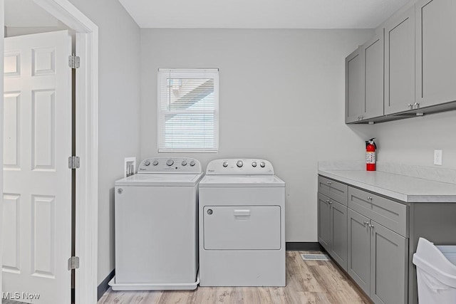 319 Sterling Ct, Akron, OH 44304 - laundry room featuring cabinet space, washing machine and clothes dryer, and light wood finished floors