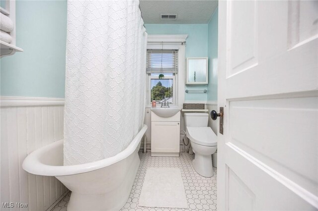 201 E Spring St, Marietta, OH 45750 - full bathroom featuring a sink, toilet, wainscoting, and shower / tub combo