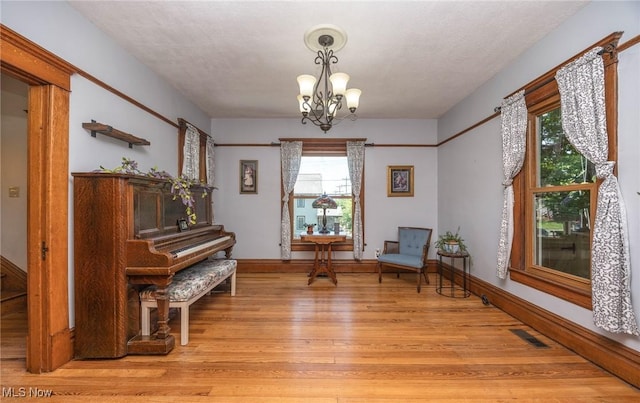 201 E Spring St, Marietta, OH 45750 - living area featuring light wood-style floors, a chandelier, and baseboards