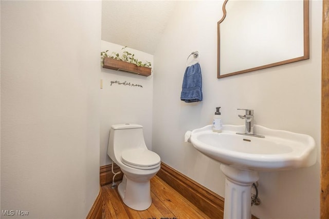 201 E Spring St, Marietta, OH 45750 - half bath featuring toilet, wood finished floors, vaulted ceiling, a textured ceiling, and baseboards
