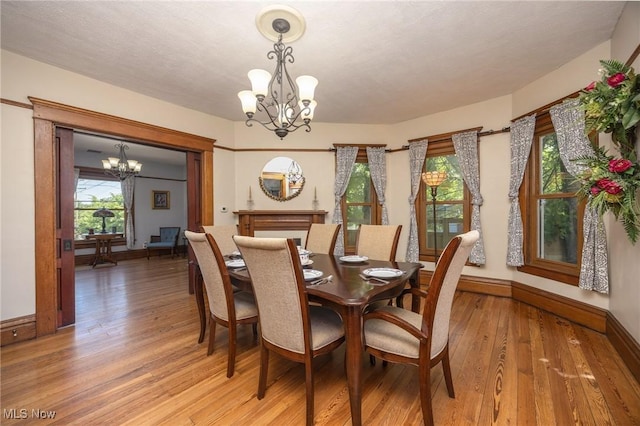 201 E Spring St, Marietta, OH 45750 - dining room featuring a chandelier, light wood-style flooring, and baseboards