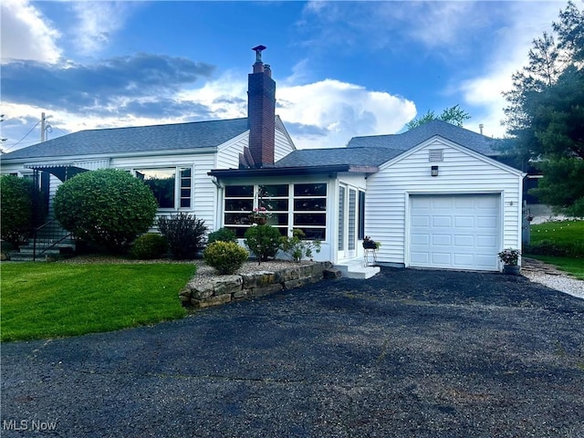 6276 Pilot Knob Ave, Louisville, OH 44641 - ranch-style house featuring an attached garage, driveway, a chimney, roof with shingles, and a front lawn