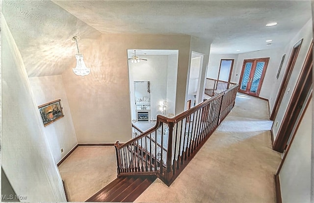 6419 S Rim Cir, Valley City, OH 44280 - stairway with carpet floors, baseboards, a chandelier, and a textured ceiling
