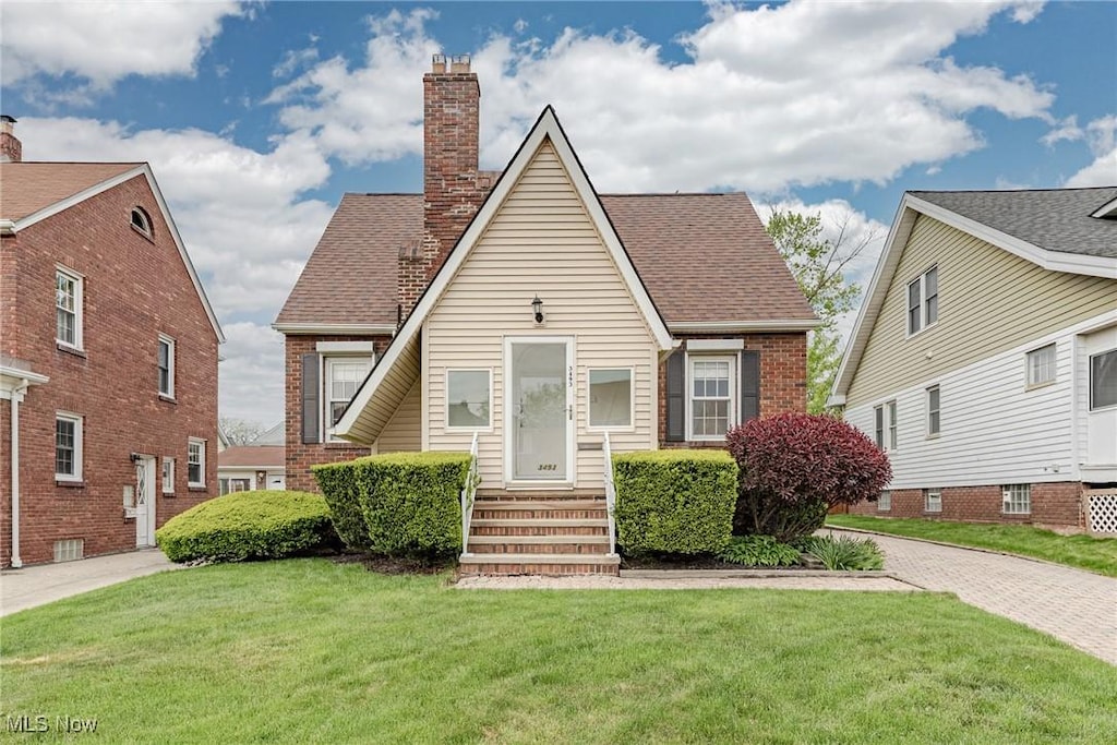 3493 W 146th St, Cleveland, OH 44111 - view of front of house with a chimney, a front yard, and brick siding