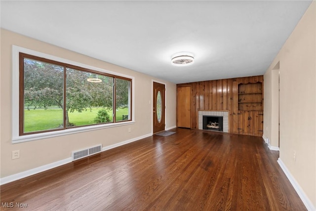 6525 Wales Ave NW, Massillon, OH 44646 - unfurnished living room featuring a brick fireplace, wood finished floors, and baseboards